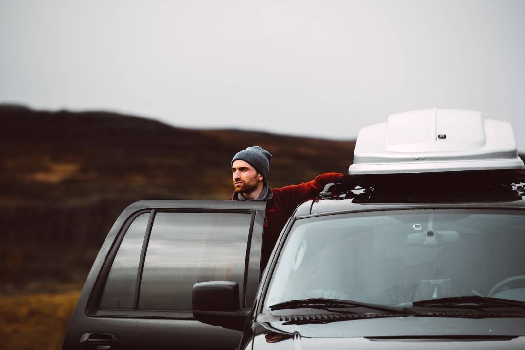 A man standing next to his black SUV